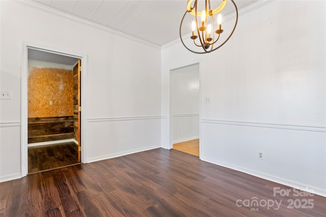 spare room with crown molding, a chandelier, and dark hardwood / wood-style floors