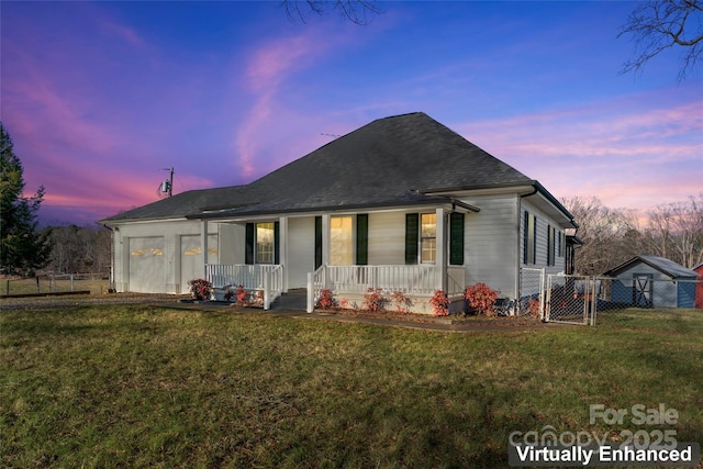 view of front of house featuring a lawn, a garage, and covered porch