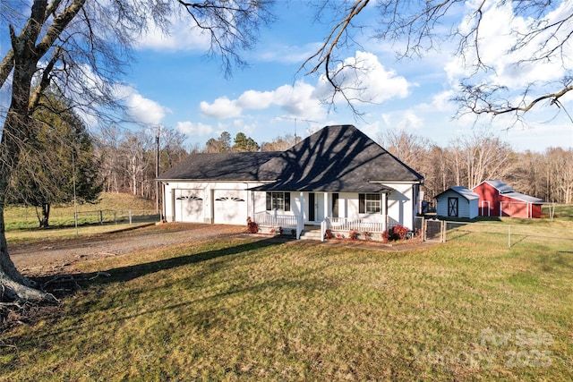 ranch-style home featuring covered porch, a garage, and a front yard