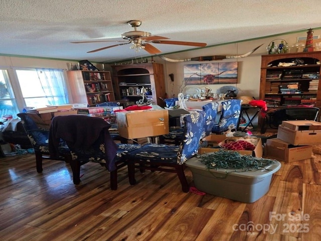 dining area featuring ceiling fan, wood-type flooring, and a textured ceiling