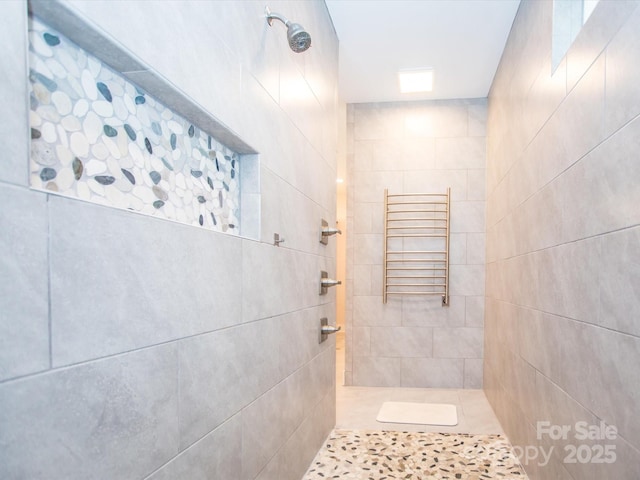 bathroom featuring tiled shower and radiator