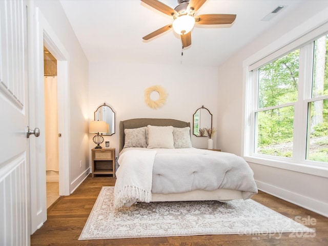 bedroom featuring multiple windows, dark hardwood / wood-style flooring, and ceiling fan