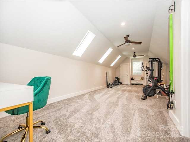 home office featuring carpet flooring, ceiling fan, and lofted ceiling with skylight