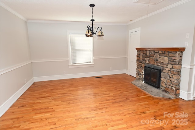 unfurnished living room with a stone fireplace, light hardwood / wood-style flooring, an inviting chandelier, and ornamental molding