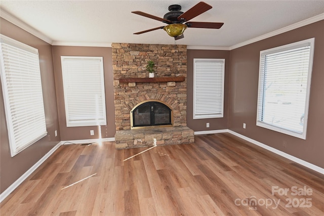 unfurnished living room featuring hardwood / wood-style floors, ceiling fan, ornamental molding, a fireplace, and a textured ceiling