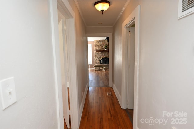 hall with dark hardwood / wood-style flooring and crown molding