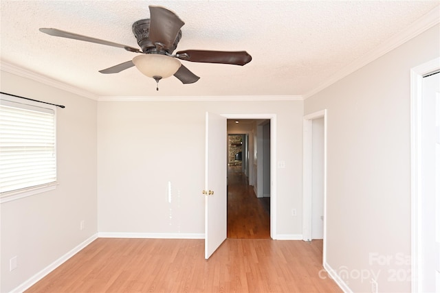 unfurnished room with crown molding, light wood-type flooring, and a textured ceiling