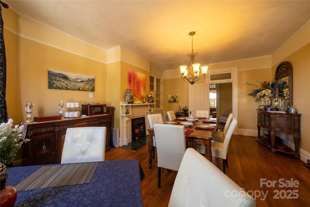 dining space featuring ornamental molding, dark hardwood / wood-style flooring, and a notable chandelier