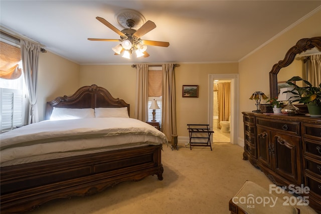 carpeted bedroom featuring ensuite bathroom, ceiling fan, and crown molding