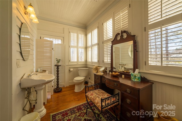 bathroom featuring hardwood / wood-style floors, toilet, and ornamental molding