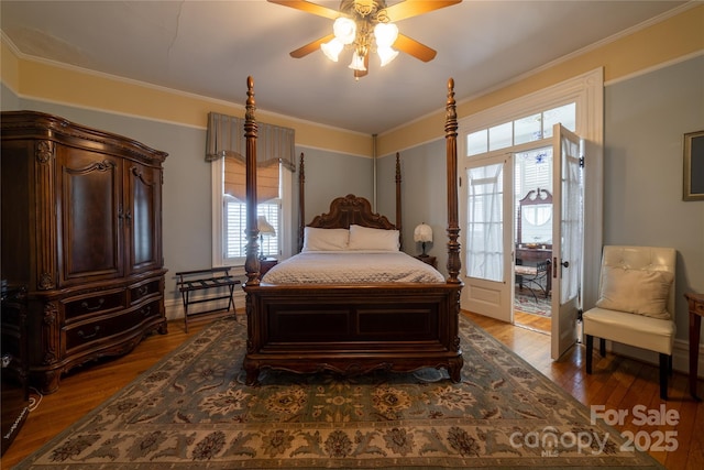 bedroom featuring hardwood / wood-style floors, ceiling fan, ornamental molding, and multiple windows