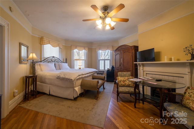 bedroom featuring wood-type flooring, ceiling fan, and ornamental molding