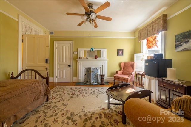 bedroom featuring ceiling fan, crown molding, and light wood-type flooring