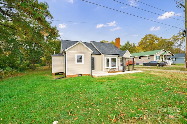 back of house featuring a lawn