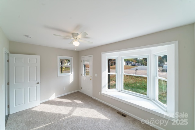 empty room with ceiling fan and light colored carpet