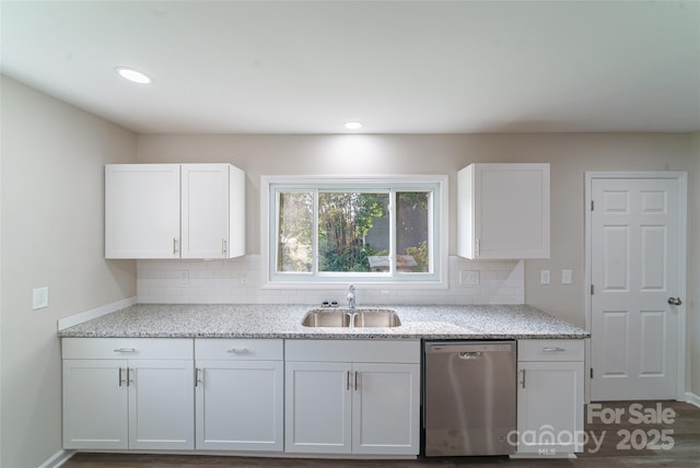 kitchen featuring dishwasher, sink, light stone counters, backsplash, and white cabinets