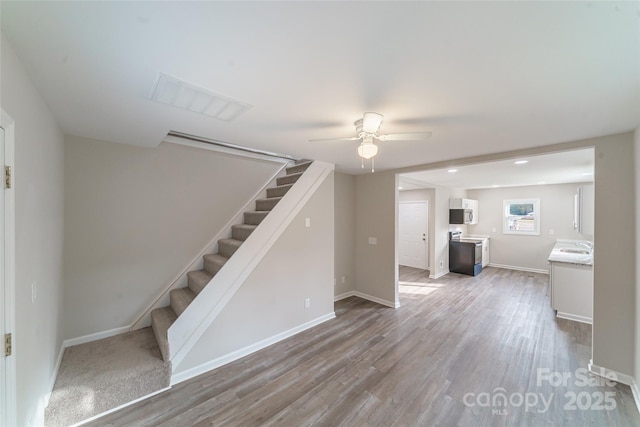 unfurnished living room with hardwood / wood-style flooring and ceiling fan