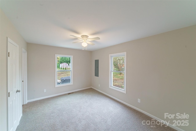 carpeted spare room with electric panel and ceiling fan