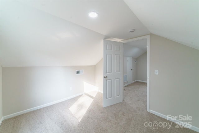 bonus room featuring lofted ceiling and light carpet