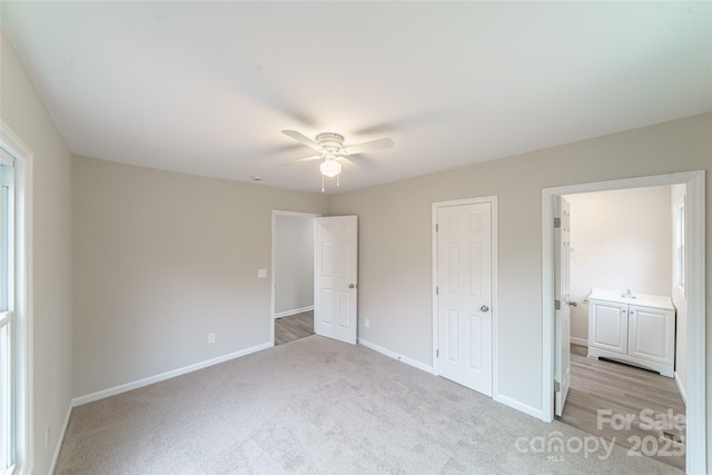 unfurnished bedroom with ceiling fan, sink, and light carpet