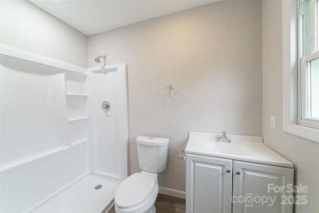 bathroom featuring vanity, toilet, and walk in shower