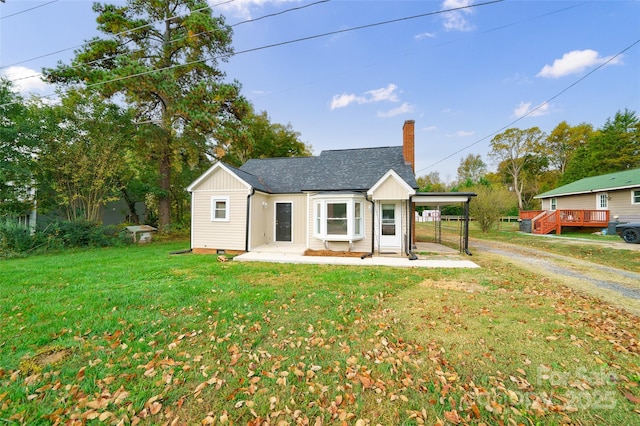 single story home featuring a front lawn and a carport