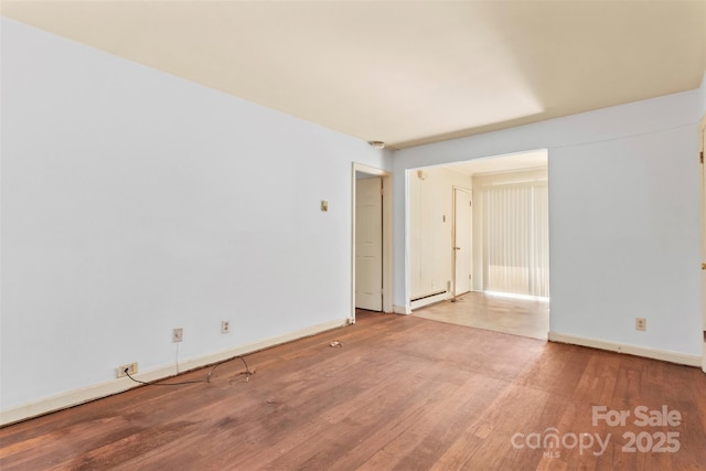 spare room with light hardwood / wood-style flooring and a baseboard radiator