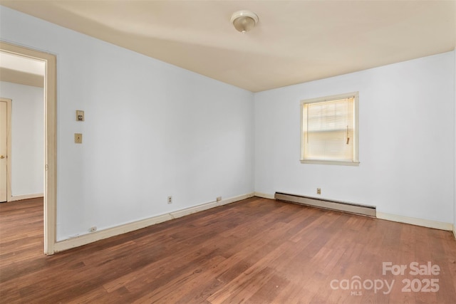 empty room with wood-type flooring and a baseboard radiator