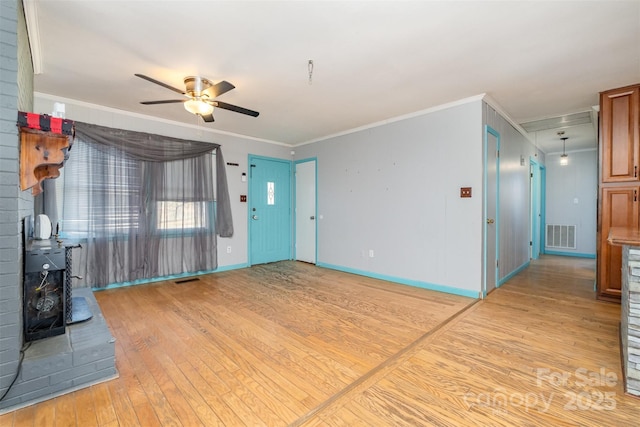 unfurnished living room with light hardwood / wood-style floors, a wood stove, ceiling fan, and crown molding