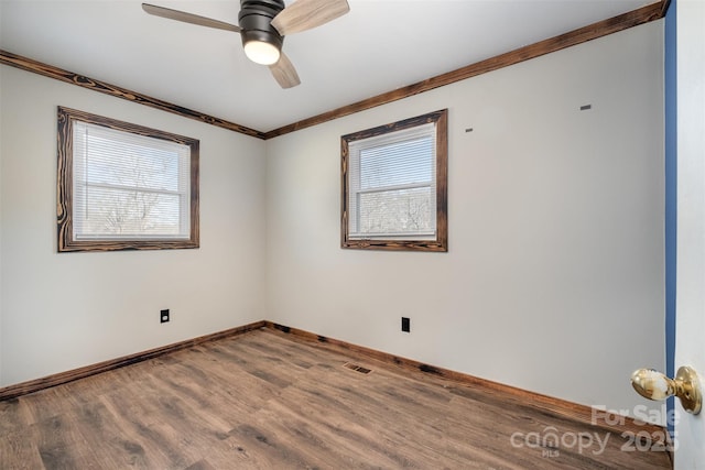 spare room with hardwood / wood-style flooring, plenty of natural light, crown molding, and ceiling fan