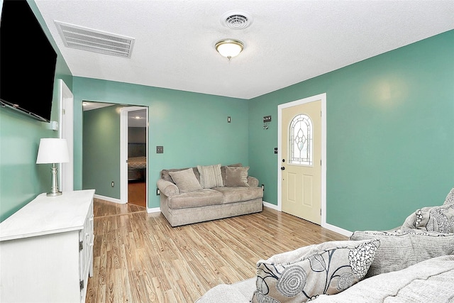 living room featuring light hardwood / wood-style floors and a textured ceiling