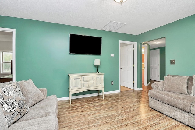 living room with wood-type flooring and a textured ceiling