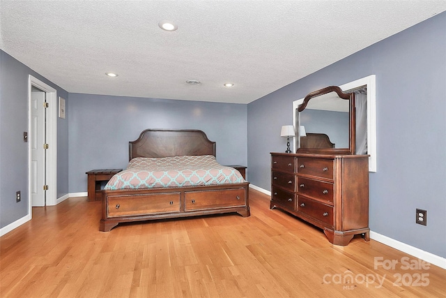 bedroom featuring a textured ceiling and light hardwood / wood-style flooring