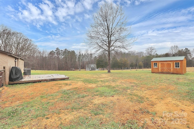 view of yard featuring a shed, central air condition unit, and a wooden deck