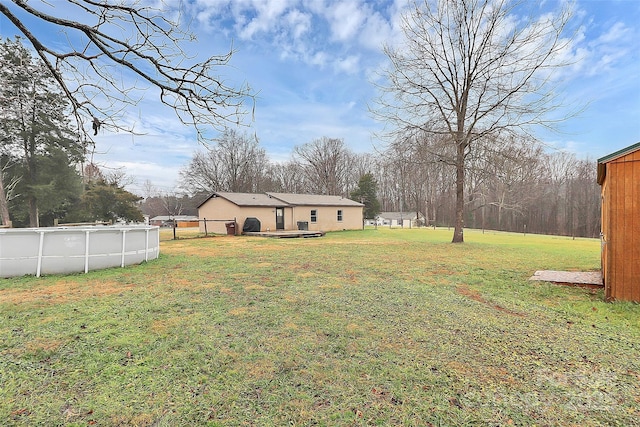 view of yard with a swimming pool side deck