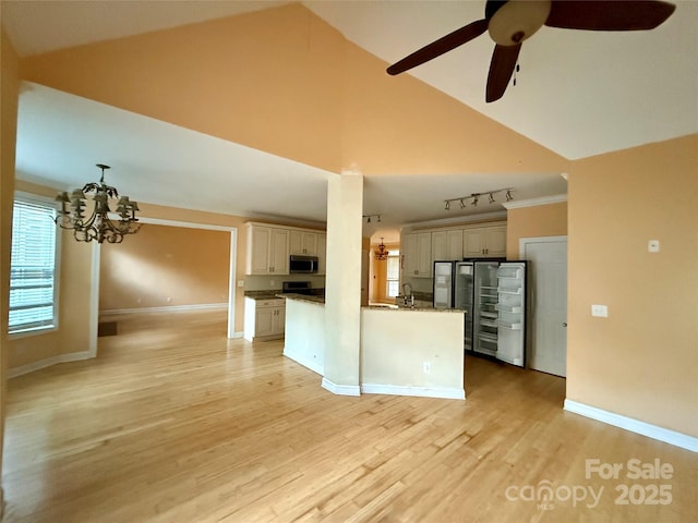 kitchen with ceiling fan with notable chandelier, sink, light hardwood / wood-style flooring, high vaulted ceiling, and a center island