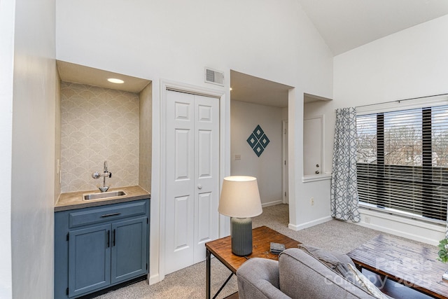 living room with high vaulted ceiling, light colored carpet, visible vents, and baseboards