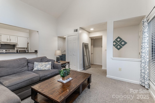 living area featuring light carpet, high vaulted ceiling, visible vents, and baseboards