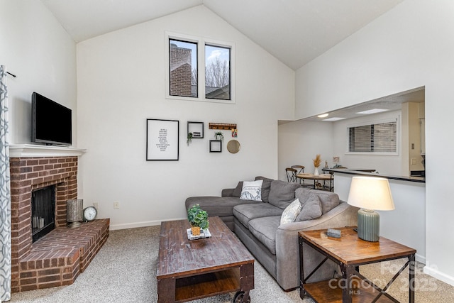 living room with high vaulted ceiling, a brick fireplace, light colored carpet, and baseboards