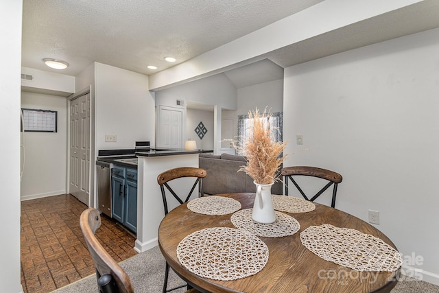 dining room with visible vents, baseboards, brick floor, a textured ceiling, and recessed lighting