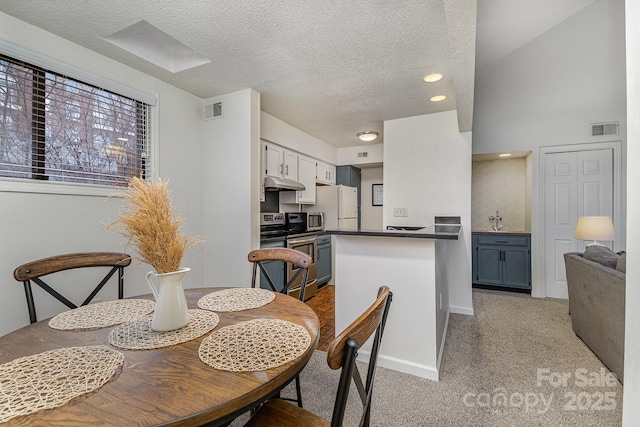 dining room with light carpet, baseboards, visible vents, and a textured ceiling