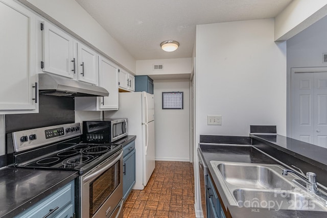 kitchen with visible vents, white cabinets, dark countertops, stainless steel appliances, and under cabinet range hood