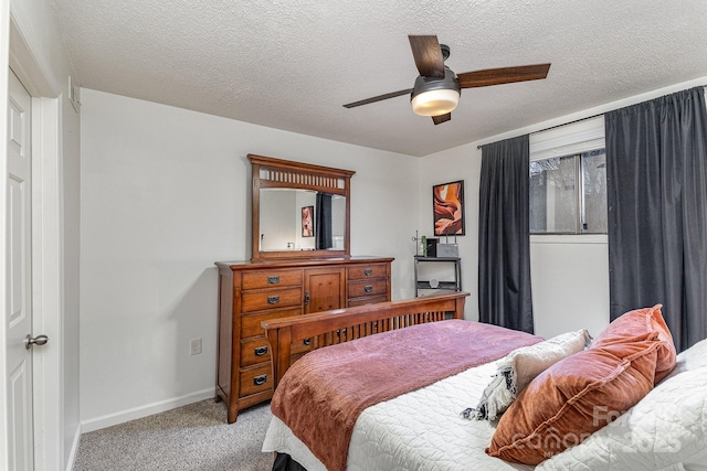 bedroom featuring a textured ceiling, baseboards, a ceiling fan, and light colored carpet