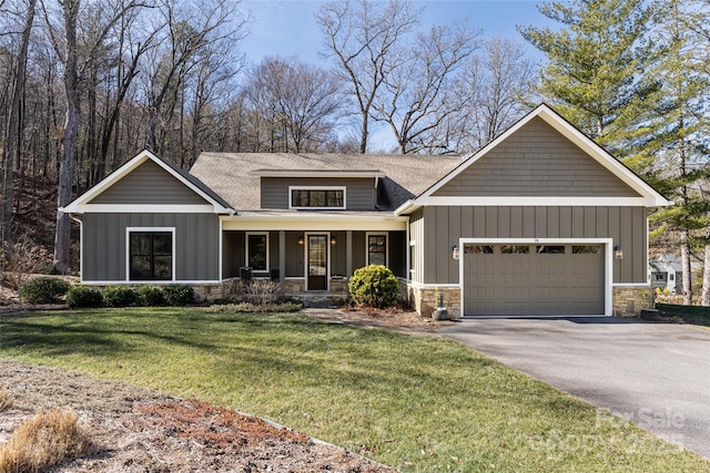 craftsman house with a garage, a front yard, and covered porch