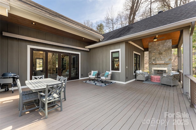 wooden terrace featuring grilling area and an outdoor stone fireplace