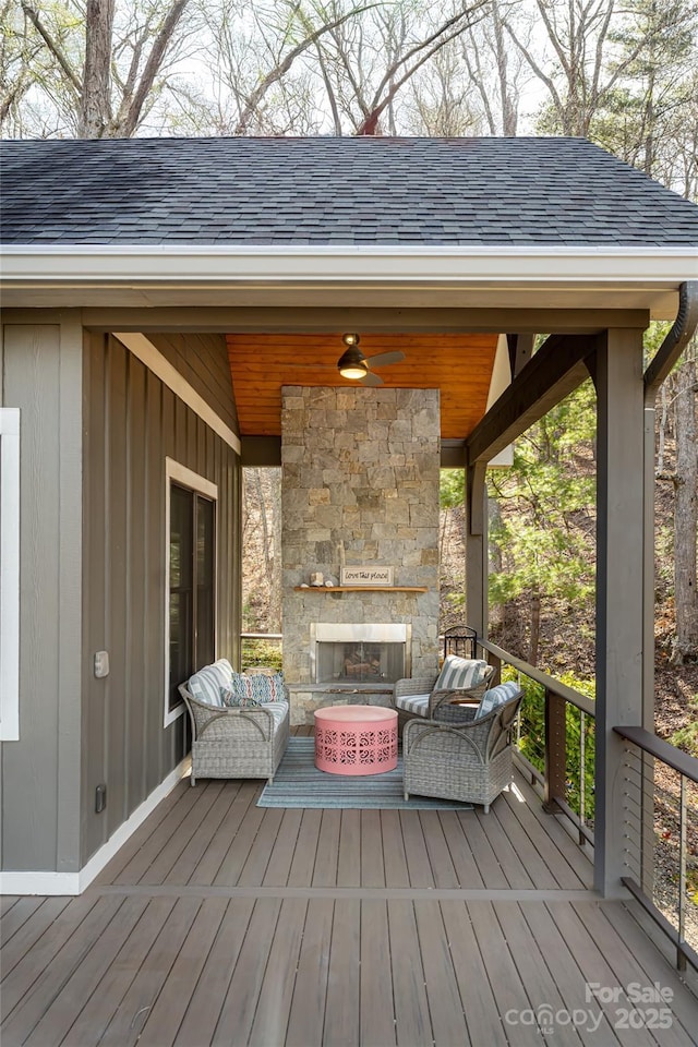 deck with ceiling fan and an outdoor living space with a fireplace