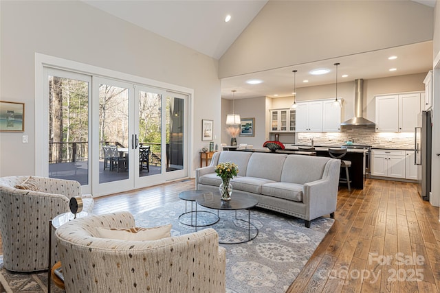 living room featuring wood-type flooring and high vaulted ceiling