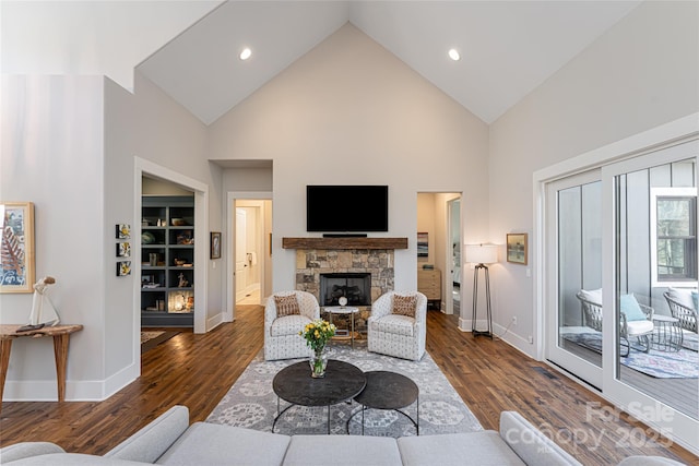 living room featuring dark hardwood / wood-style flooring, a fireplace, and high vaulted ceiling