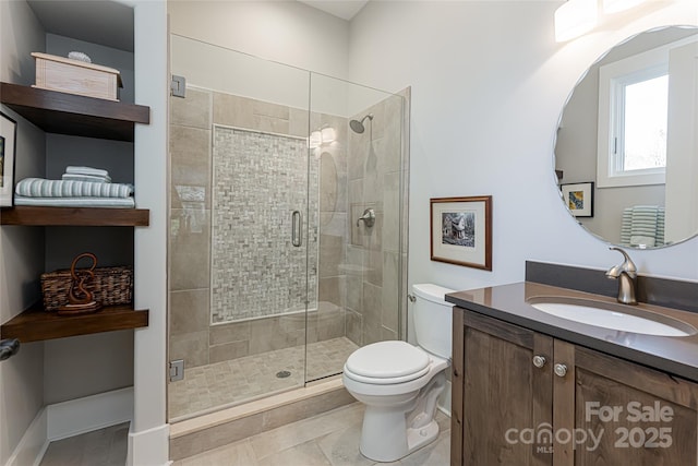 bathroom with vanity, tile patterned flooring, toilet, and walk in shower