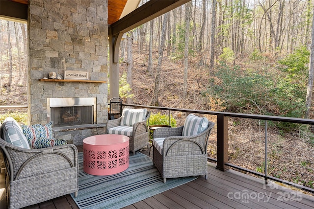 wooden deck with an outdoor stone fireplace